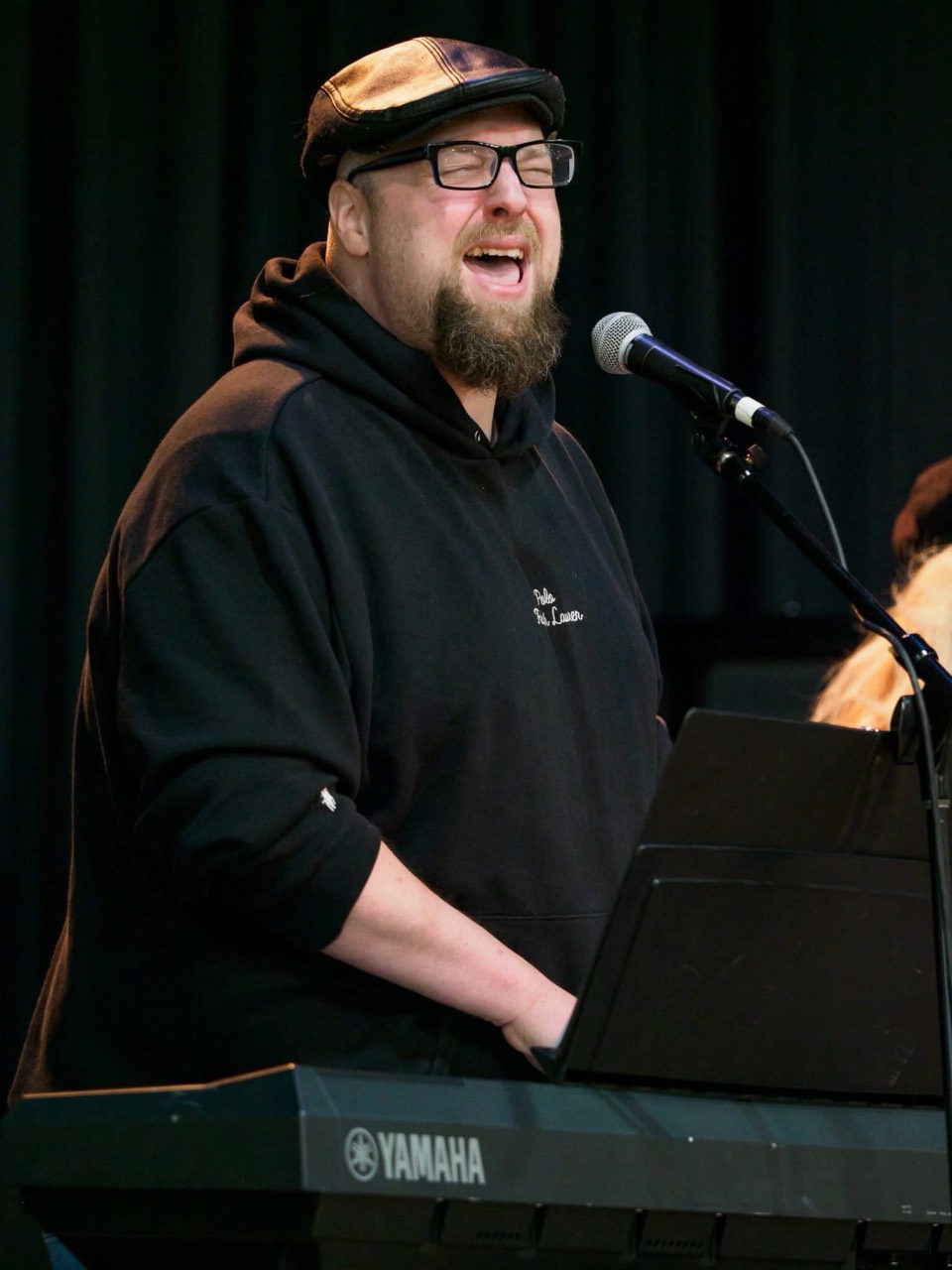 Thomas Griffin singing and playing the keyboard during worship
